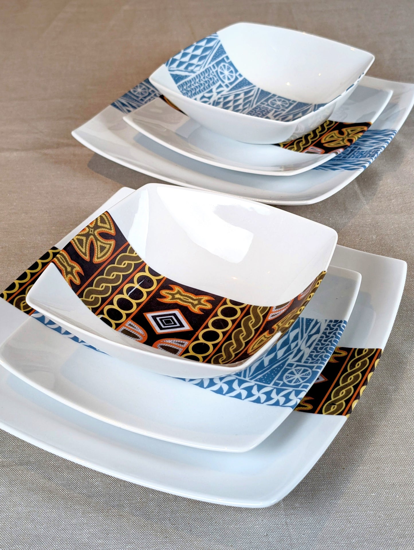 Coffret d'assiettes carrées en porcelaine fine Française fabriquées à la demande avec motif bande ethnique d'Afrique "Ndop" noir du Cameroun, présenté dans un coffret de 6 assiettes.