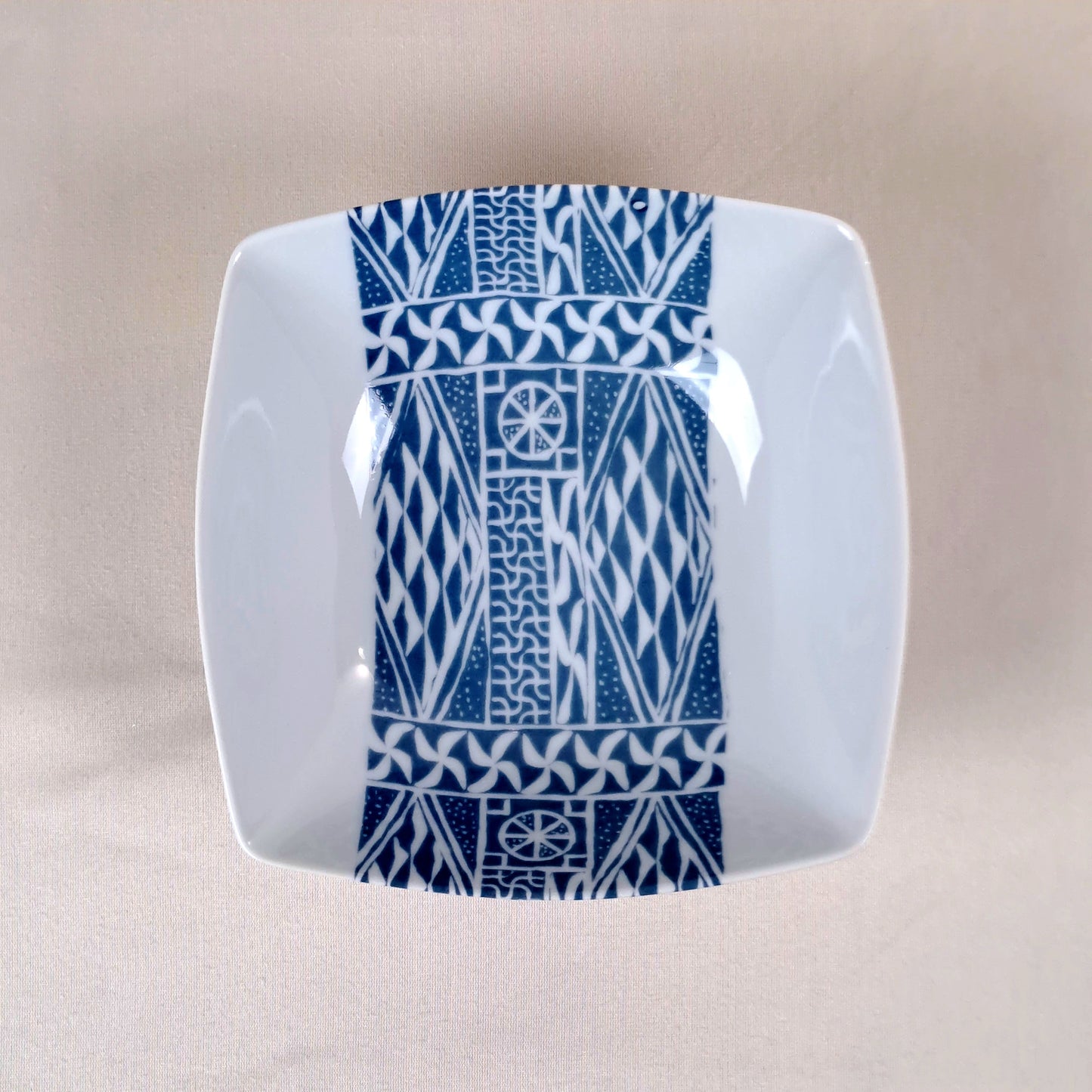 Coffret d'assiettes carrées en porcelaine fine Française fabriquées à la demande avec motif bande ethnique d'Afrique "Ndop" bleu du Cameroun, présenté dans un coffret de 6 assiettes.