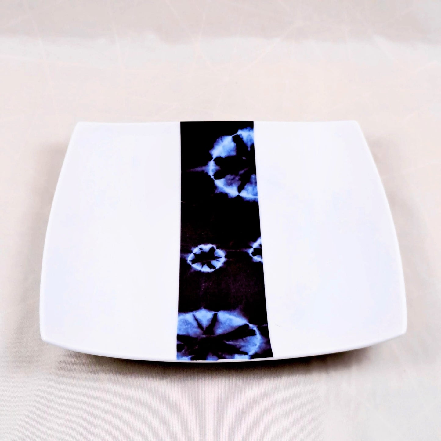 Coffret d'assiettes carrées en porcelaine fine Française fabriquées à la demande avec motif bande ethnique d'Afrique "Indigo bleu et noir" , présenté dans un coffret de 6 assiettes.