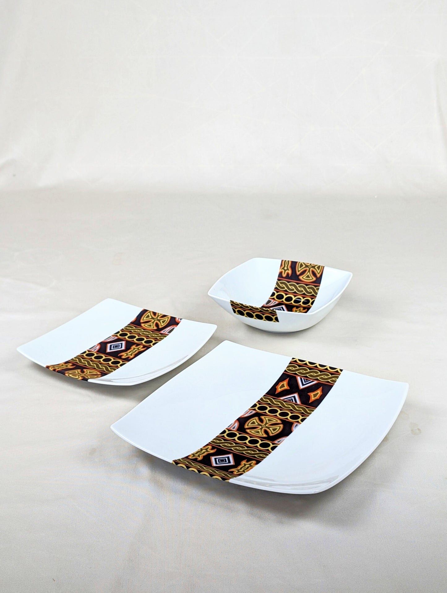 Coffret d'assiettes carrées en porcelaine fine Française fabriquées à la demande avec motif bande ethnique d'Afrique "Ndop" noir du Cameroun, présenté dans un coffret de 6 assiettes.