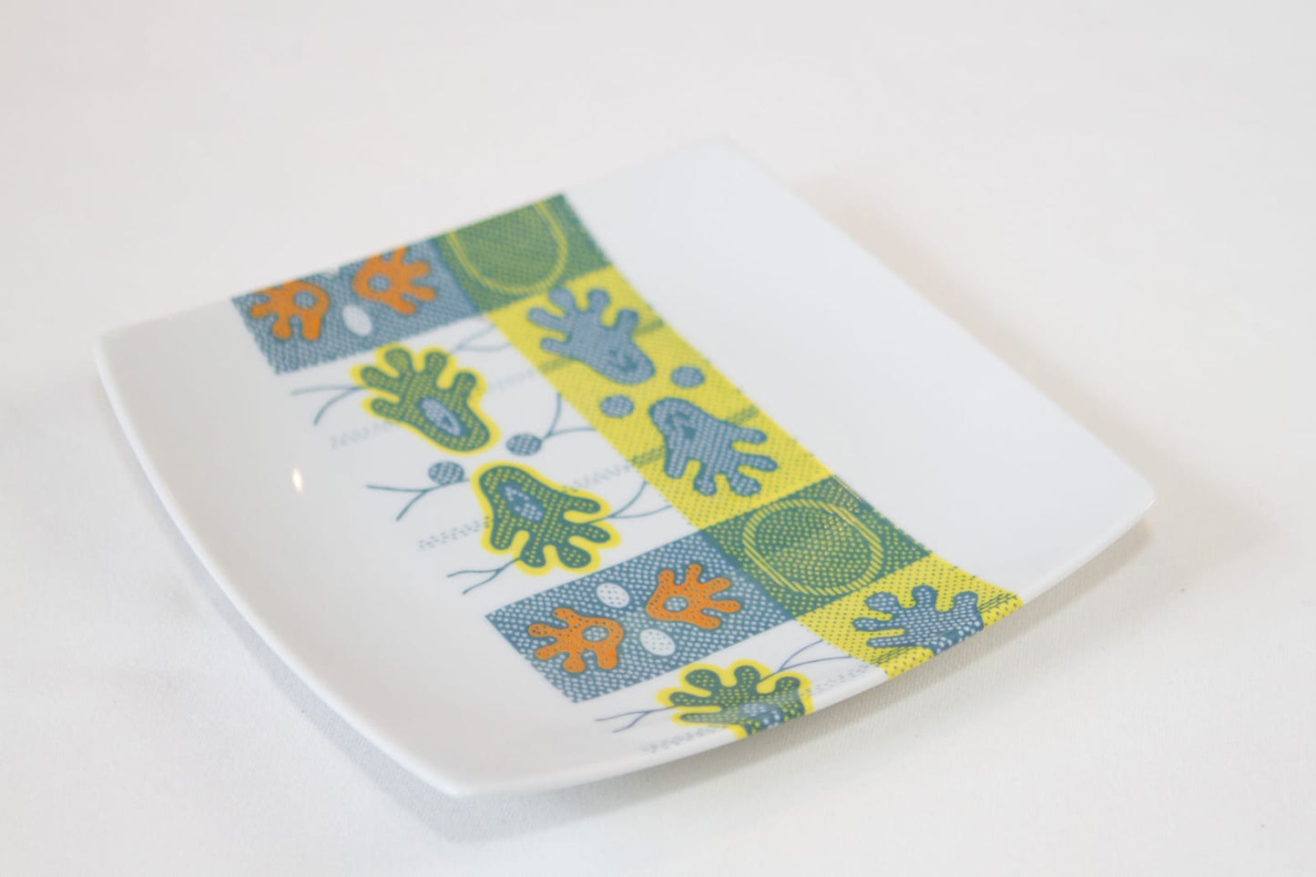 Coffret d'assiettes carrées en porcelaine fine Française fabriquées à la demande avec motif bande WAX d'afrique "Ton pied Mon pied" dans coffret de 12