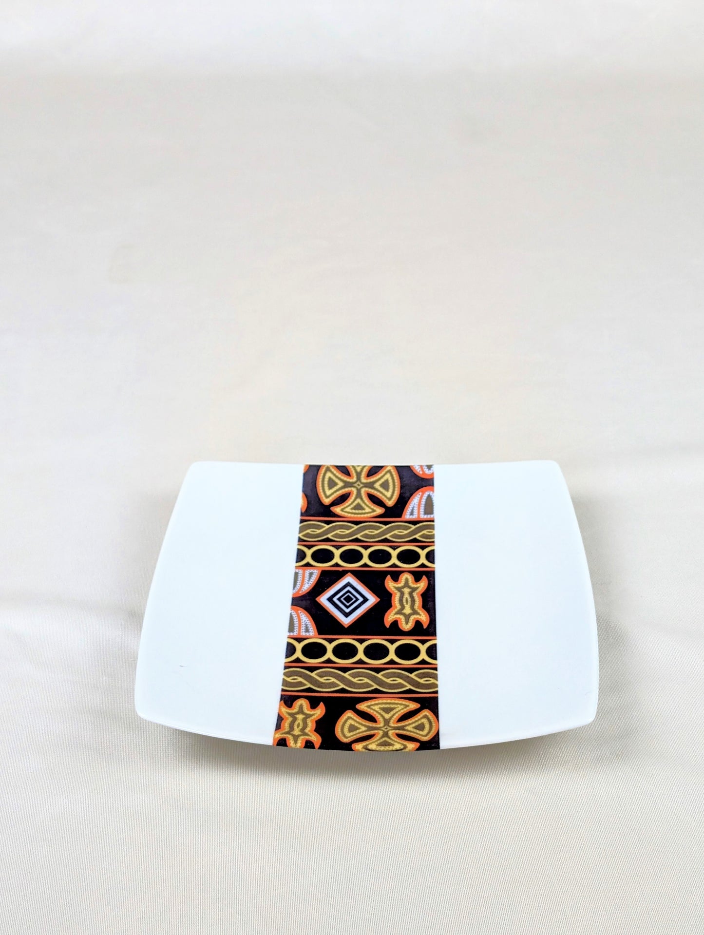 Coffret d'assiettes carrées en porcelaine fine Française fabriquées à la demande avec motif bande ethnique d'Afrique "Ndop" noir du Cameroun, présenté dans un coffret de 6 assiettes.