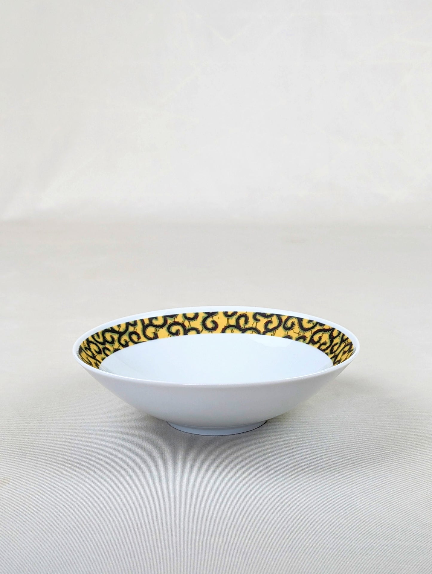 Coffret d'assiettes rondes en porcelaine fine Française fabriquées à la demande avec motif anneaux fins WAX d'afrique "Macaroni ou Conseiller" jaune dans coffret de 6 assiettes.