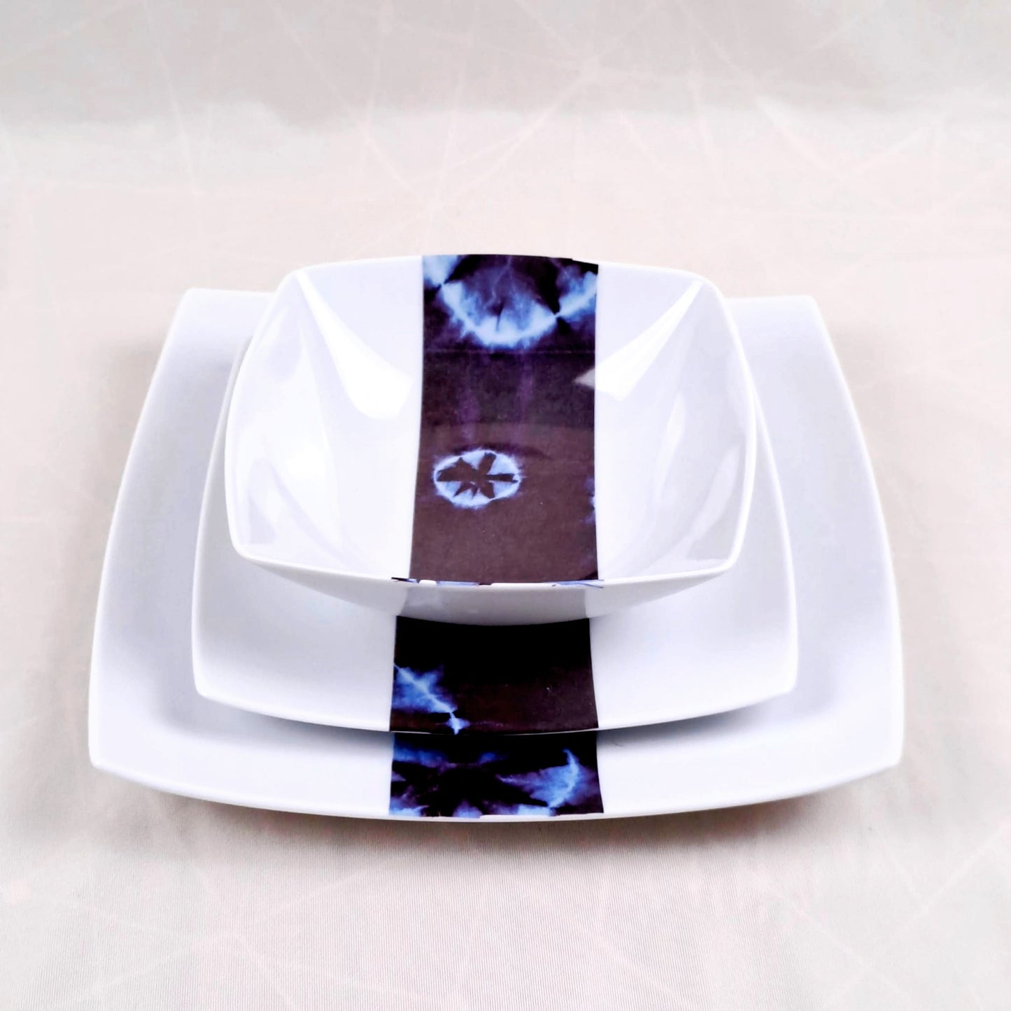 Coffret d'assiettes carrées en porcelaine fine Française fabriquées à la demande avec motif bande ethnique d'Afrique "Indigo bleu et noir" , présenté dans un coffret de 6 assiettes.