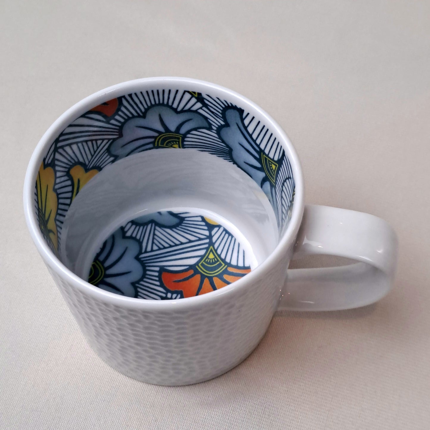 Mug en porcelaine fine Française grenaillé à l'extérieur, motif wax d'Afrique "Fleurs de Mariage" à l'intérieur
