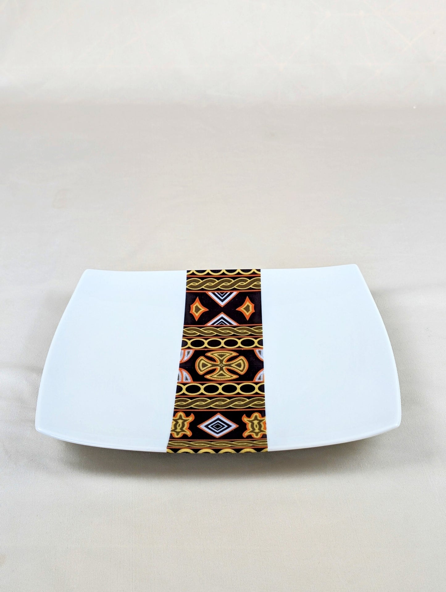 Coffret d'assiettes carrées en porcelaine fine Française fabriquées à la demande avec motif bande ethnique d'Afrique "Ndop" noir du Cameroun, présenté dans un coffret de 6 assiettes.
