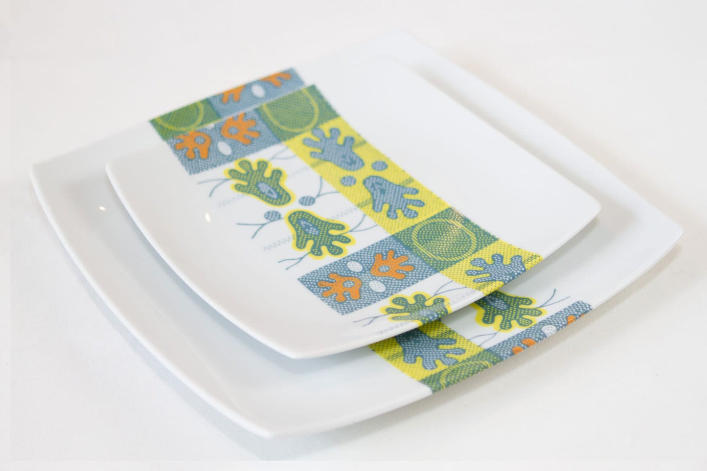 Coffret d'assiettes carrées en porcelaine fine Française fabriquées à la demande avec motif bande WAX d'afrique "Ton pied Mon pied" dans coffret de 12