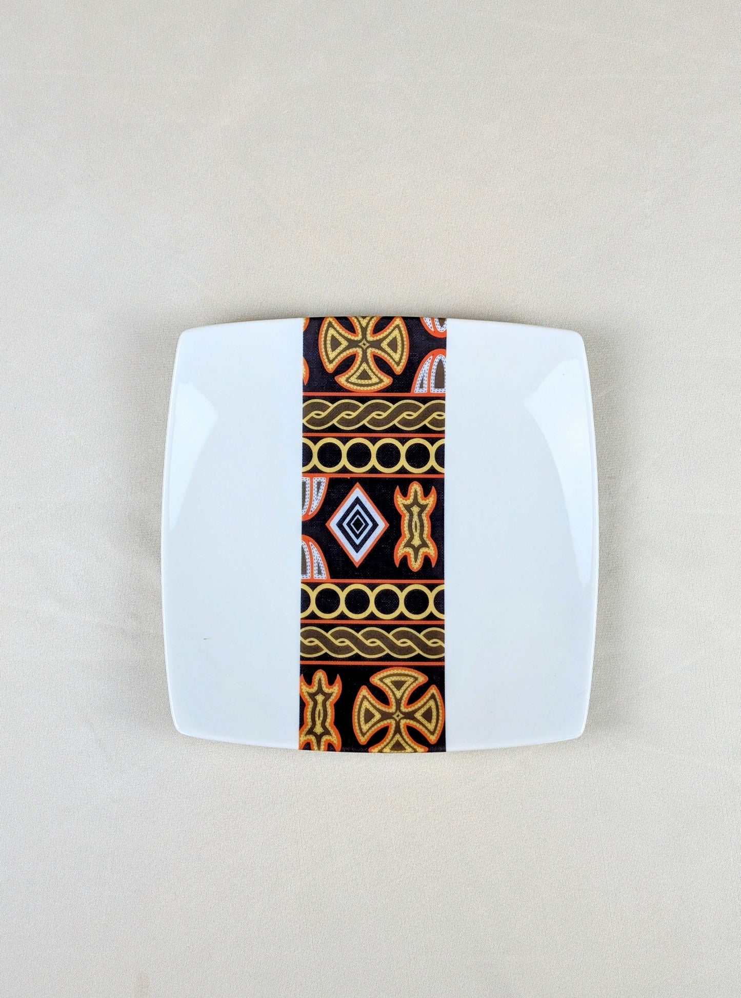 Coffret d'assiettes carrées en porcelaine fine Française fabriquées à la demande avec motif bande ethnique d'Afrique "Ndop" noir du Cameroun, présenté dans un coffret de 6 assiettes.